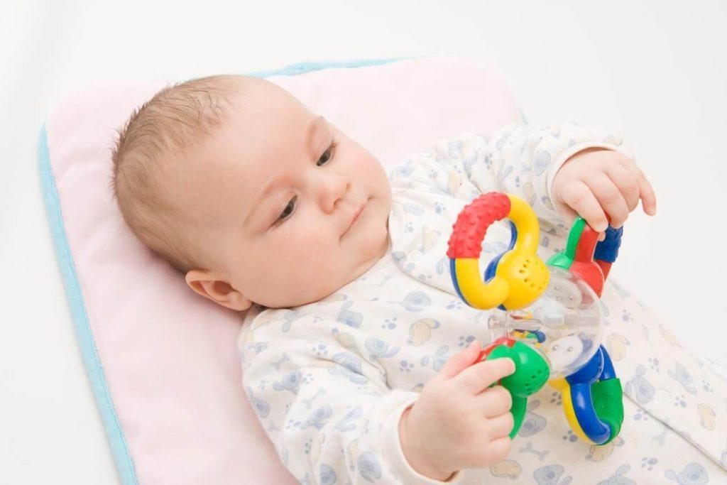 Ребенок осознанно рассматривает игрушку и пытается играть
