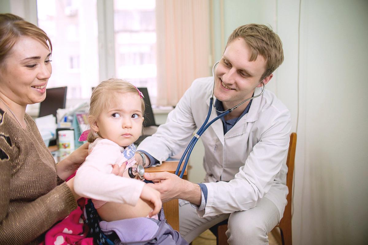 Девочку слушает врач